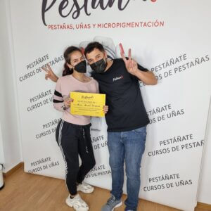 Alumna concentrada aprendiendo técnica de extensiones de pestañas
