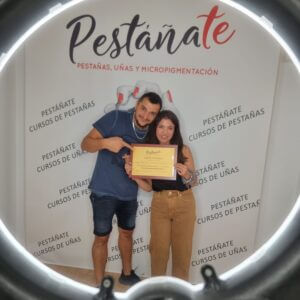 Alumna feliz con su diploma del curso de extensiones de pestañas